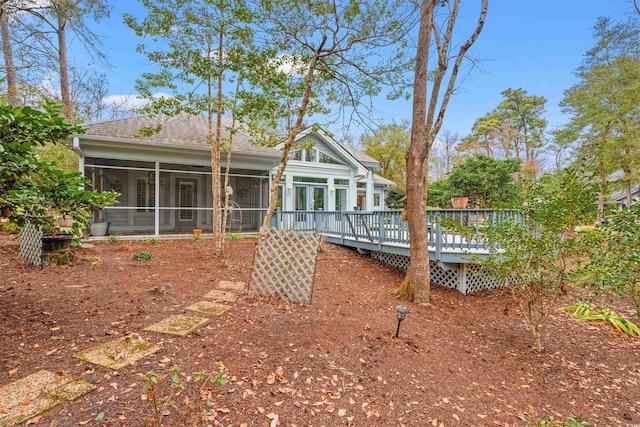 rear view of property with a wooden deck and a sunroom