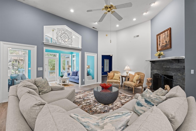 living room with a high ceiling, wood-type flooring, and ceiling fan