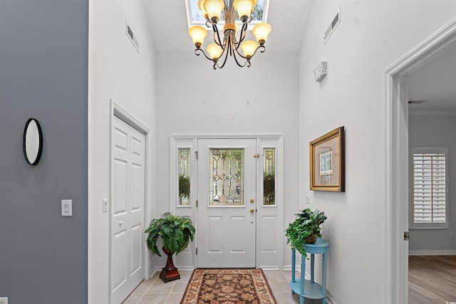 tiled entryway with a chandelier