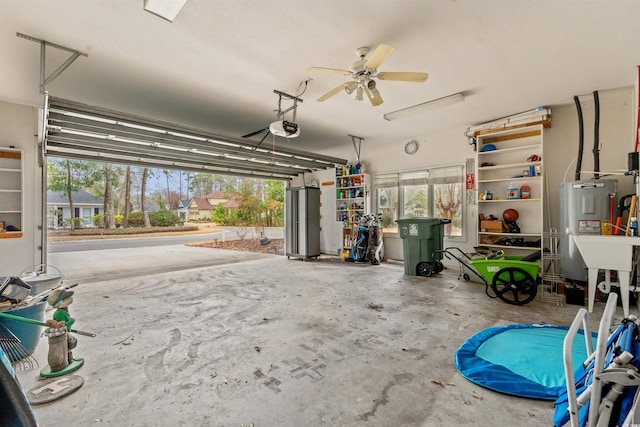 garage featuring a garage door opener, water heater, and ceiling fan