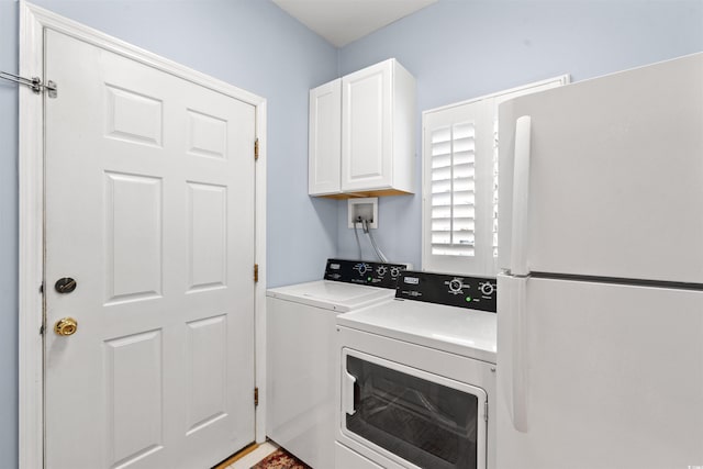 clothes washing area featuring washing machine and dryer and cabinets