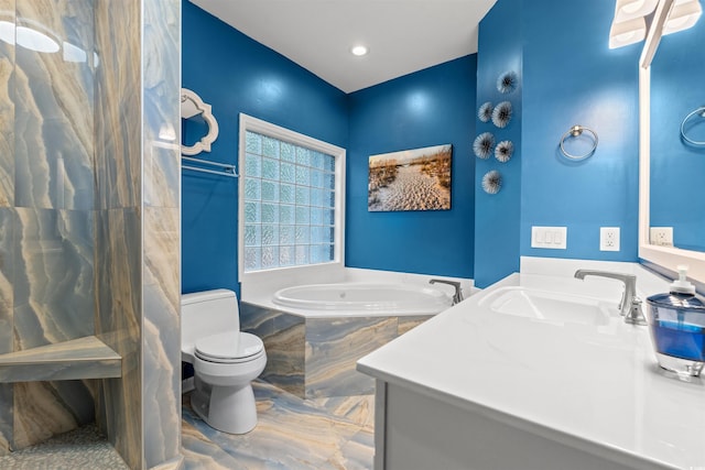 bathroom featuring vanity, tiled tub, and toilet