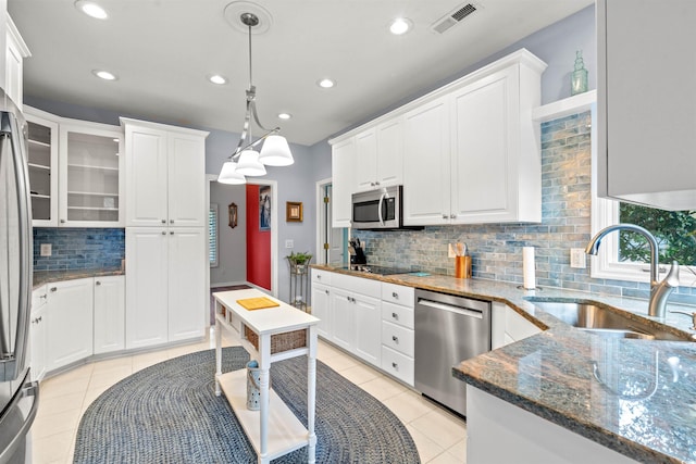 kitchen featuring light tile patterned flooring, sink, white cabinetry, hanging light fixtures, and appliances with stainless steel finishes