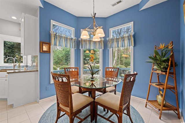 tiled dining room featuring an inviting chandelier and sink