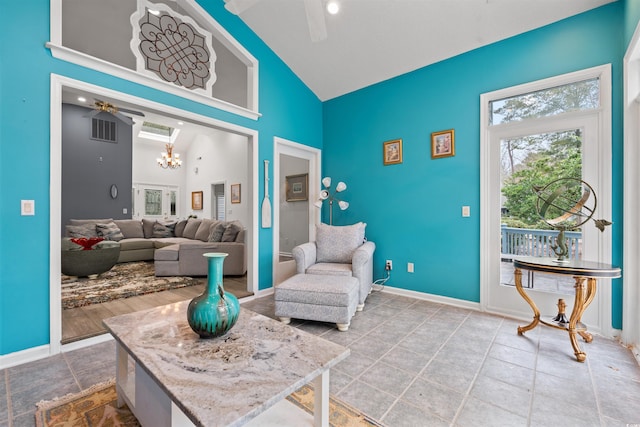 living area with ceiling fan with notable chandelier and high vaulted ceiling