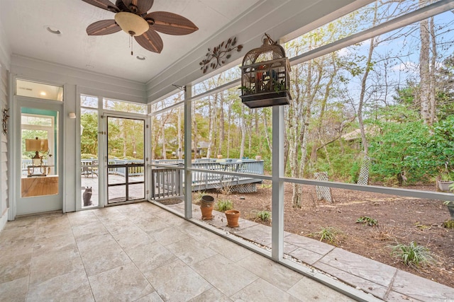 unfurnished sunroom with ceiling fan