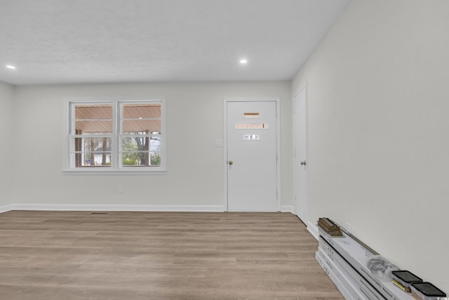 entryway featuring light wood finished floors, baseboards, and recessed lighting