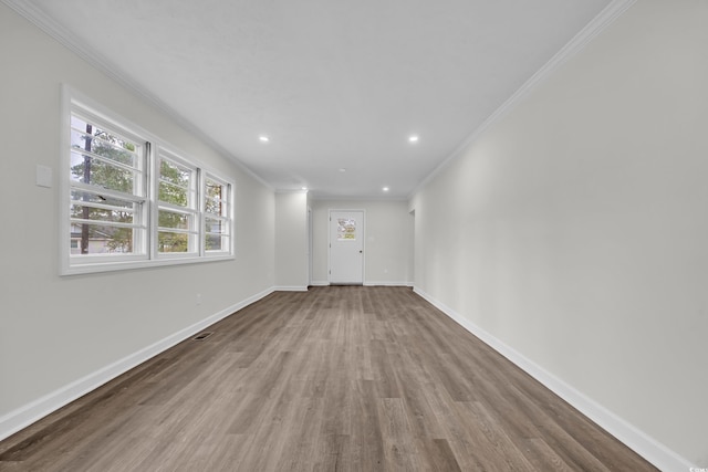 unfurnished living room with baseboards, ornamental molding, wood finished floors, and recessed lighting