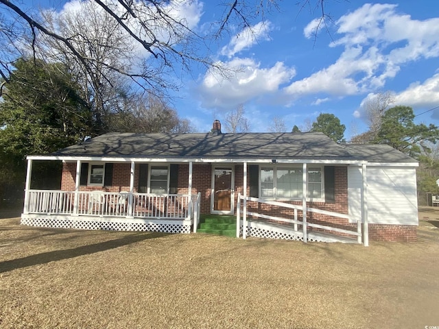 ranch-style house with a front lawn and covered porch