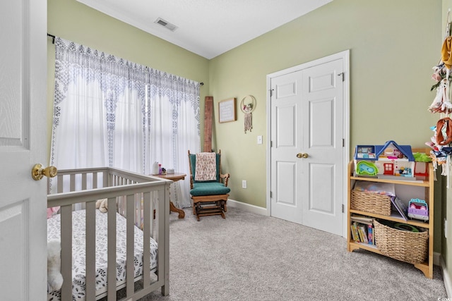 bedroom featuring carpet flooring and a crib