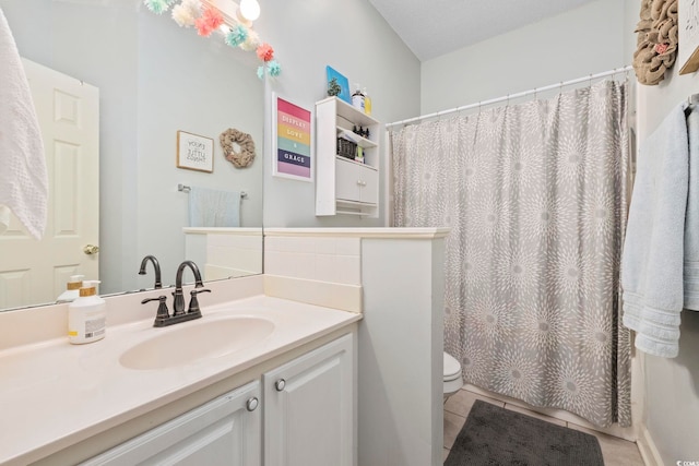 bathroom featuring vanity, tile patterned floors, and toilet