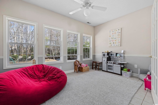 playroom featuring ceiling fan, a textured ceiling, and light tile patterned flooring