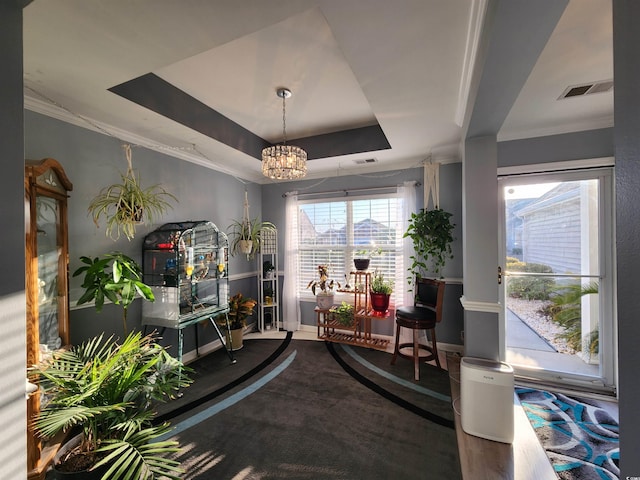 sitting room with a raised ceiling, ornamental molding, and an inviting chandelier