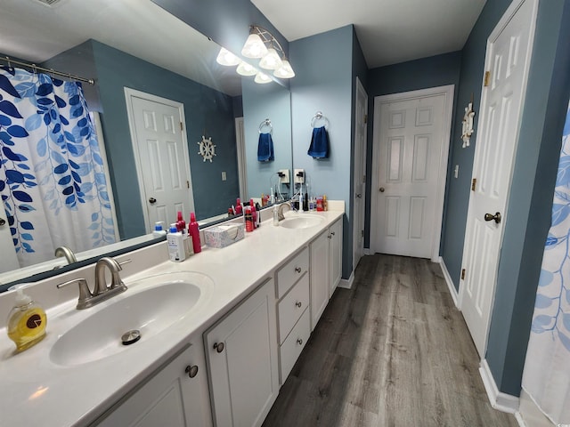 bathroom featuring walk in shower, vanity, and wood-type flooring