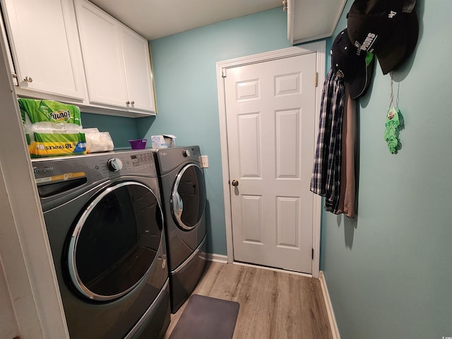 laundry room with cabinets, washer and clothes dryer, and light hardwood / wood-style floors