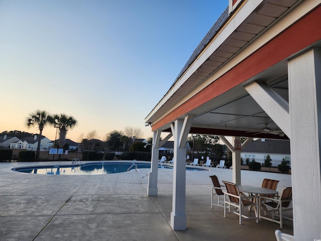 pool at dusk featuring a patio