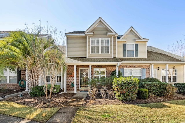 traditional home featuring brick siding and a shingled roof