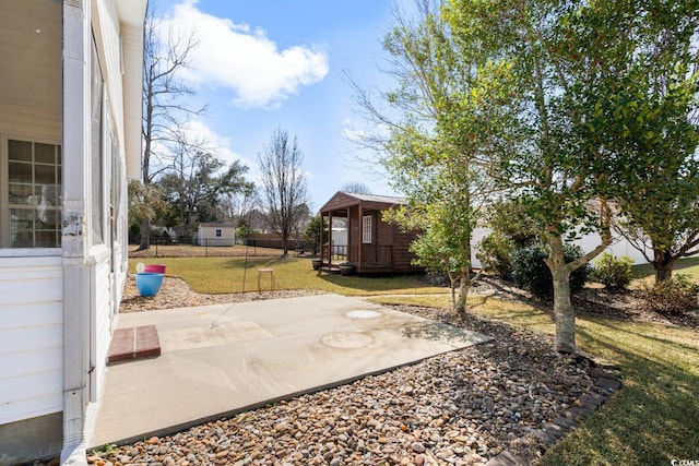 view of yard with a patio area, fence, and an outdoor structure