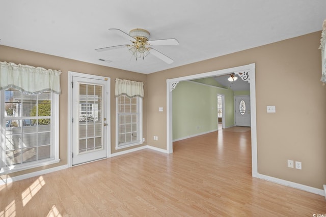 unfurnished room featuring visible vents, light wood-type flooring, a ceiling fan, and baseboards