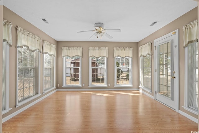 unfurnished sunroom with ceiling fan and visible vents