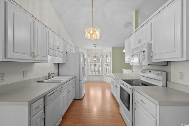 kitchen featuring white appliances, a sink, white cabinets, and light wood-style floors