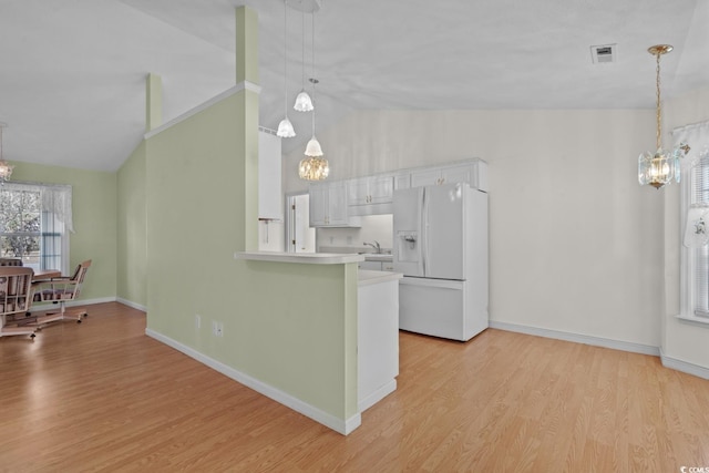 kitchen with light wood-style floors, visible vents, white refrigerator with ice dispenser, and a chandelier