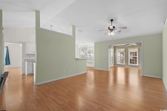 unfurnished living room with light wood-style floors, lofted ceiling, baseboards, and a ceiling fan