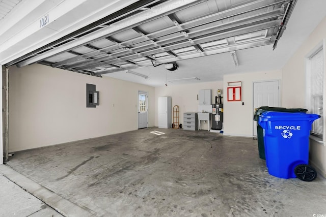 garage with a garage door opener, electric panel, water heater, and a sink