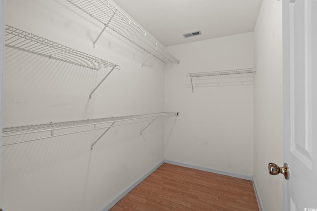 spacious closet with light wood-style floors and visible vents