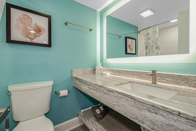 bathroom featuring sink, a shower with shower curtain, and toilet