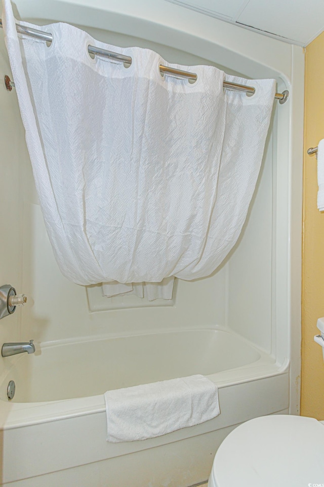 bathroom with shower / bathtub combination with curtain and toilet