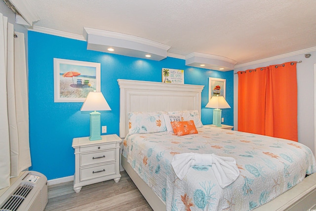 bedroom featuring light wood-type flooring, crown molding, and a textured ceiling