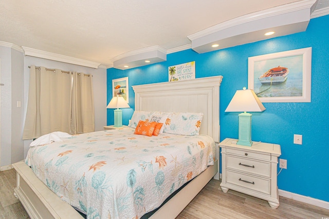 bedroom with light hardwood / wood-style flooring and crown molding