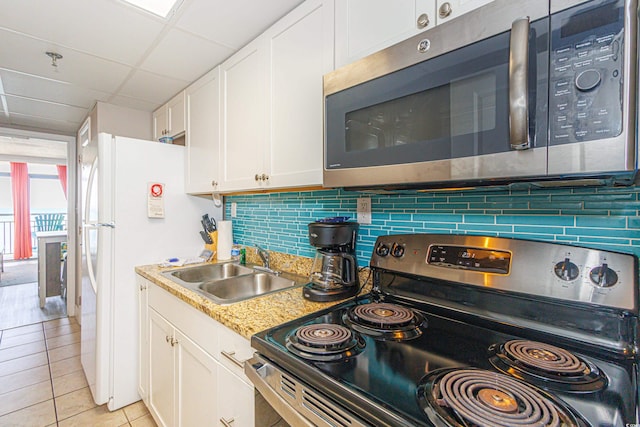 kitchen featuring appliances with stainless steel finishes, decorative backsplash, sink, and white cabinets