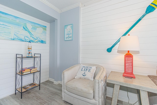 living area featuring crown molding and wood-type flooring