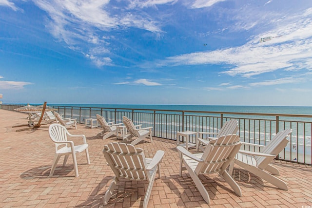 view of patio / terrace featuring a water view and a view of the beach