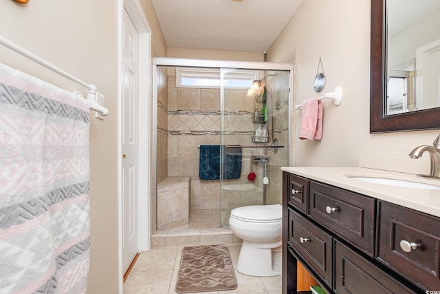 bathroom with vanity, toilet, a shower with shower door, and a textured ceiling