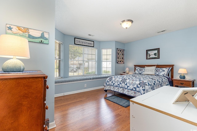 bedroom featuring hardwood / wood-style floors and a textured ceiling