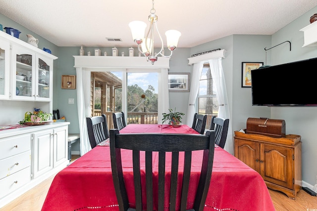 dining space featuring a notable chandelier and light wood-type flooring