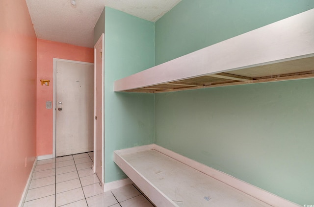 mudroom featuring a textured ceiling and light tile patterned floors