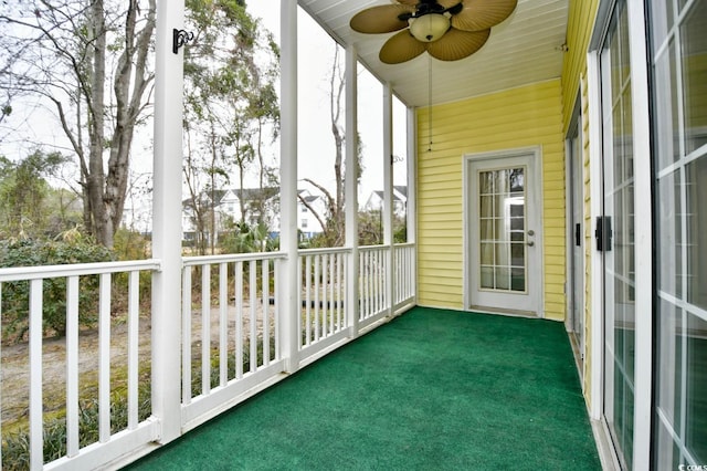 unfurnished sunroom with ceiling fan