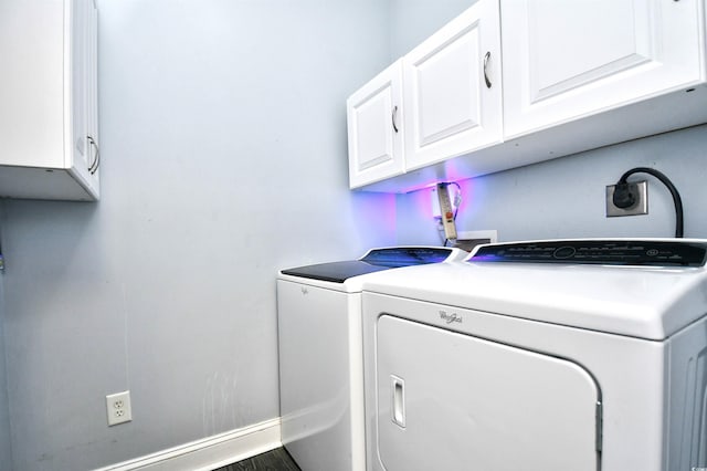 clothes washing area with washing machine and dryer and cabinets