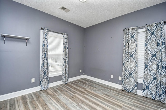 spare room with wood-type flooring and a textured ceiling