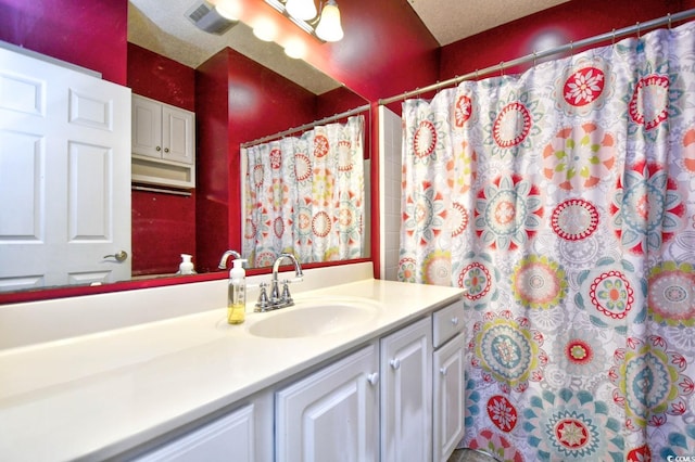 bathroom with vanity and a textured ceiling