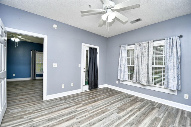 spare room featuring ceiling fan, a textured ceiling, and light wood-type flooring