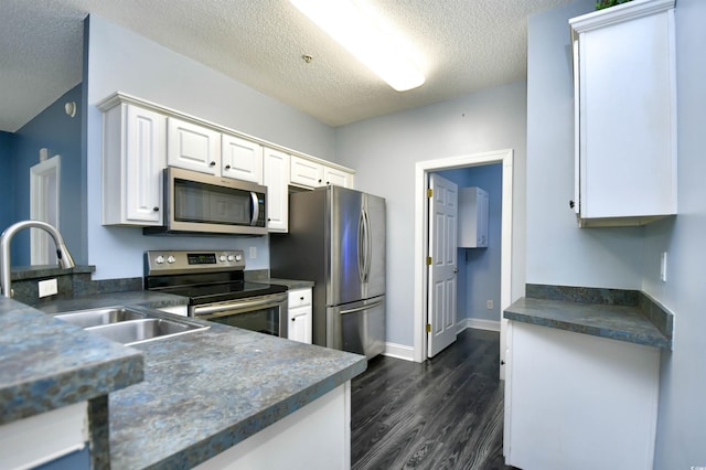 kitchen with dark wood-type flooring, sink, a textured ceiling, stainless steel appliances, and white cabinets