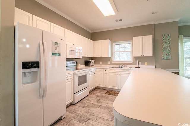 kitchen featuring crown molding, sink, white appliances, and white cabinets