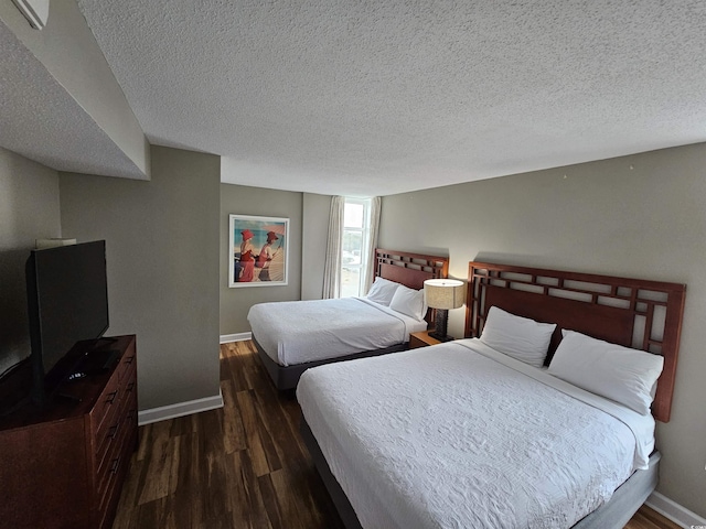 bedroom featuring dark wood-type flooring and a textured ceiling