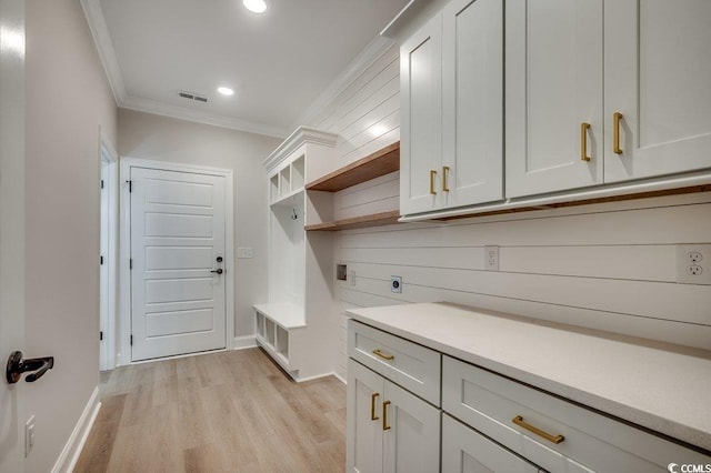 mudroom featuring baseboards, light wood-style flooring, visible vents, and ornamental molding