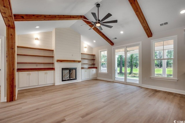 unfurnished living room featuring visible vents, a ceiling fan, beam ceiling, a fireplace, and light wood-style flooring